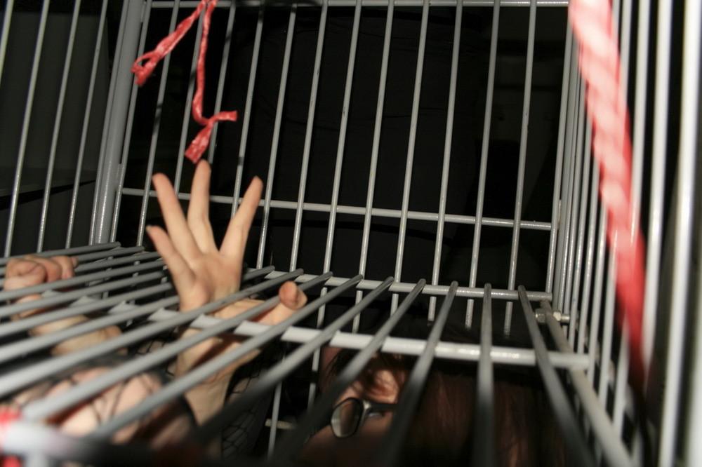 16P Marcy is tied tight into a tiny little cage on wheels.