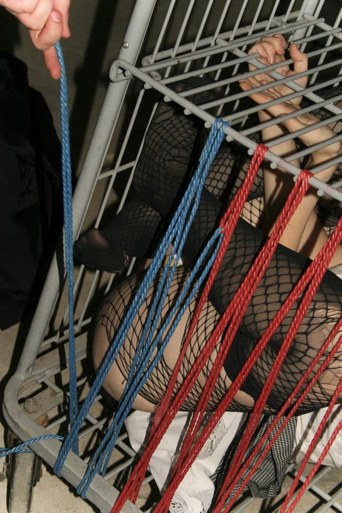 16P Marcy is tied tight into a tiny little cage on wheels.
