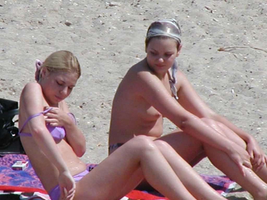 15P Watch this busty nudist rubbing sand on her body