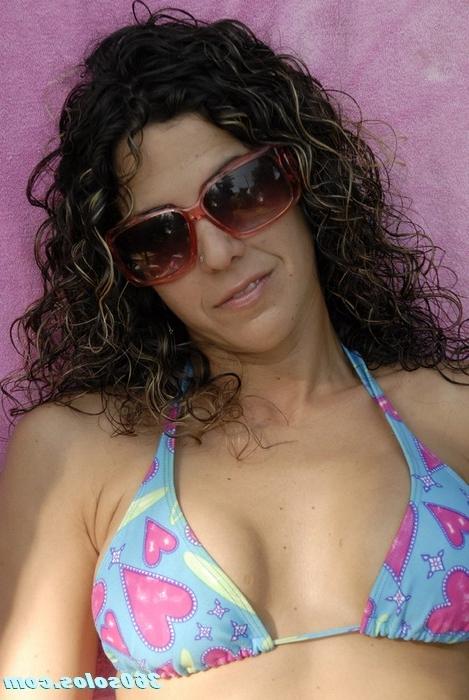 15P Sexy brunette puts lotion on her big tits while laying out