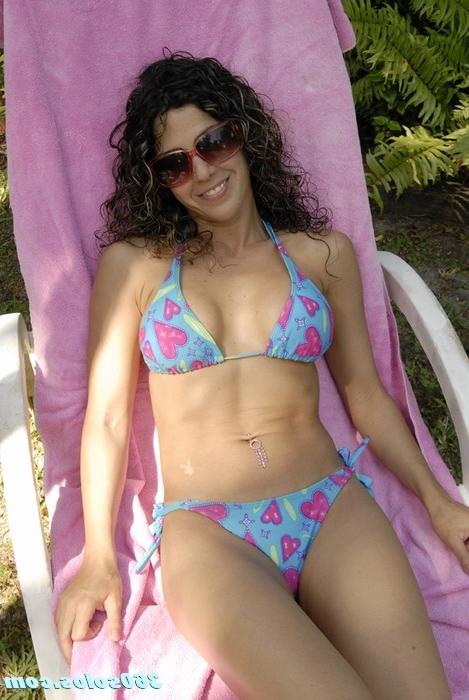 15P Sexy brunette puts lotion on her big tits while laying out