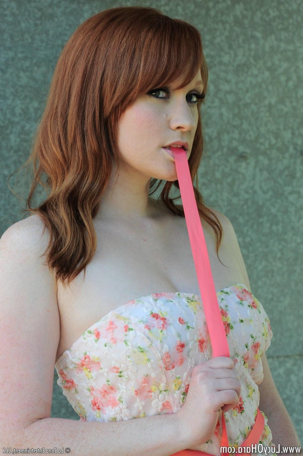 15P Busty redhead Lucy strips outside
