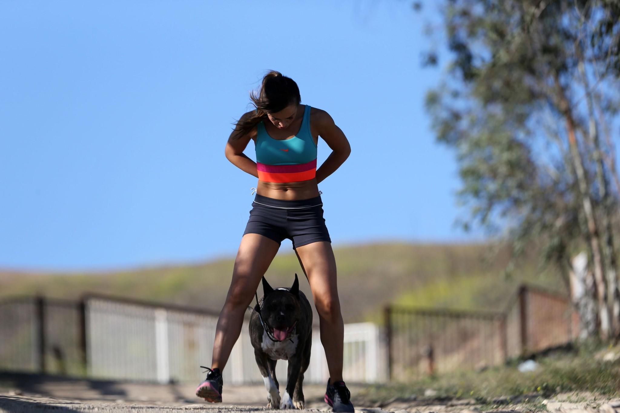 16P Karina Smirnoff in sports bra and shorts hiking with a dog at the park in LA