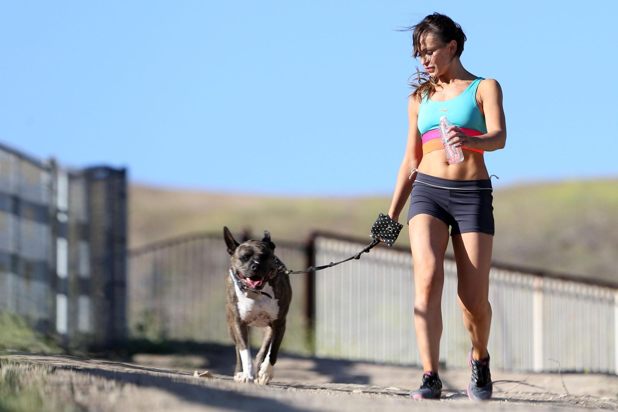 16P Karina Smirnoff in sports bra and shorts hiking with a dog at the park in LA