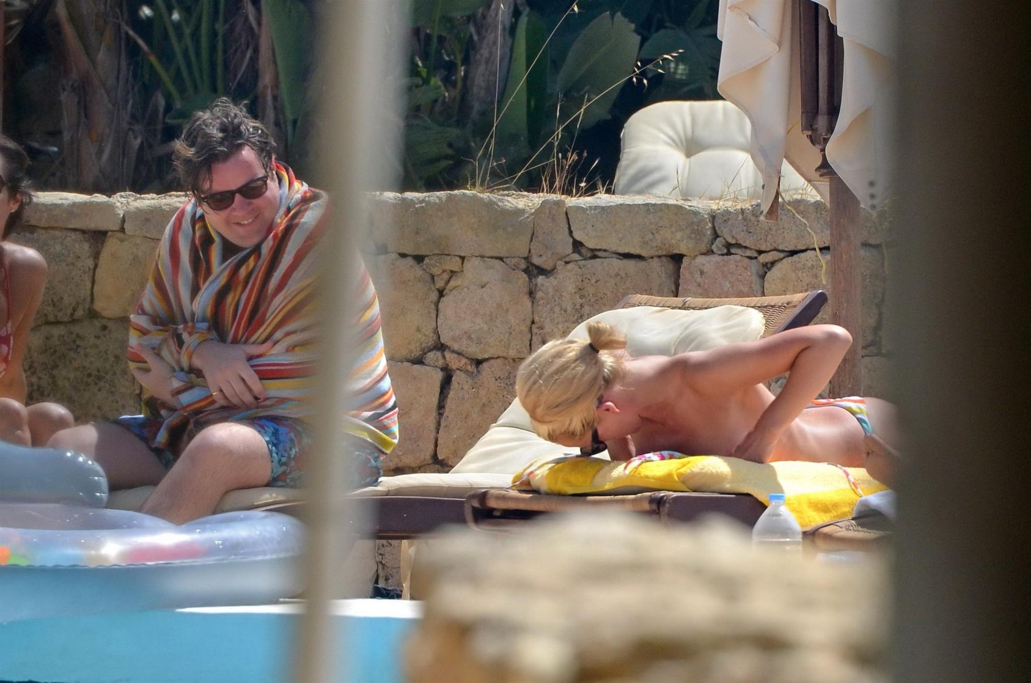 10P Katherine Jenkins in black bikini  tanning topless on a holiday in Malta