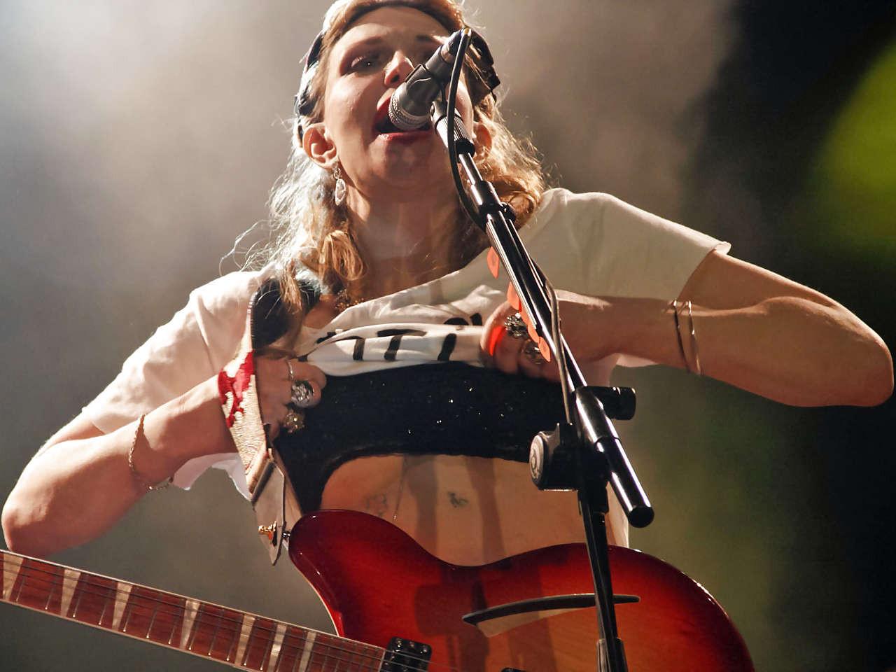 16P Courtney Love stripping down to topless and show tits on stage
