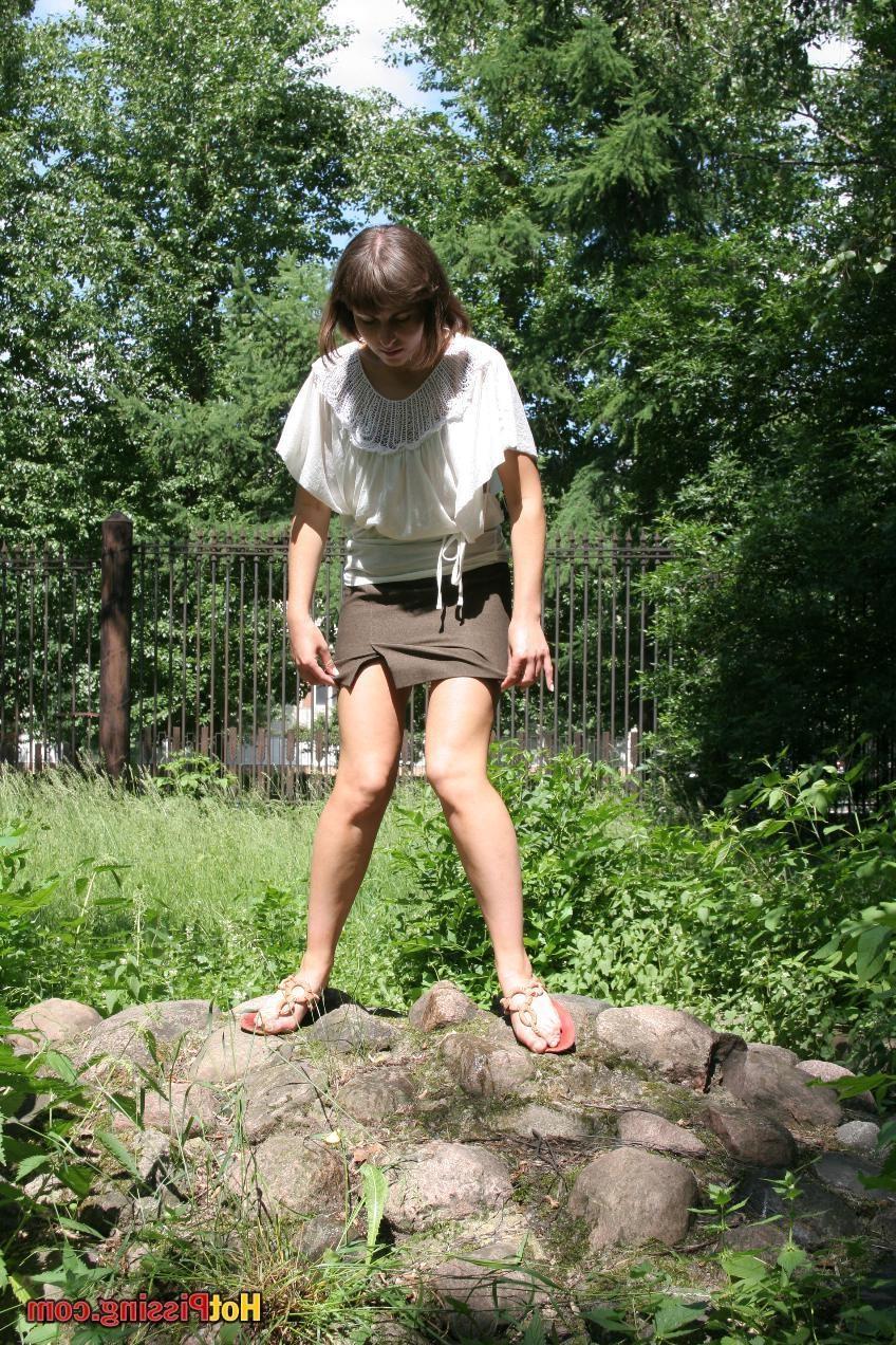 15P Pretty girl in a brown mini skirt with a cut splashes on the stones