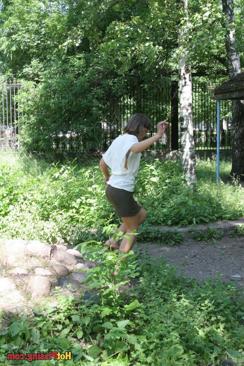 15P Pretty girl in a brown mini skirt with a cut splashes on the stones