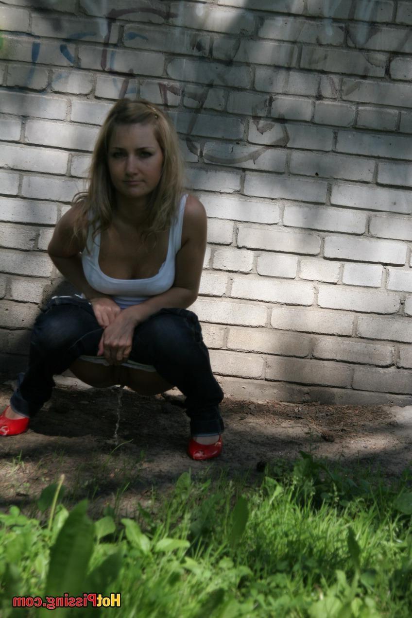 15P Blonde babe in a white tee and jeans shows her peeing pussy outdoors