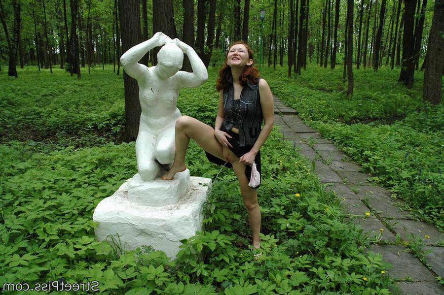 12P Shy redhead spreads legs to wet a park sculpture