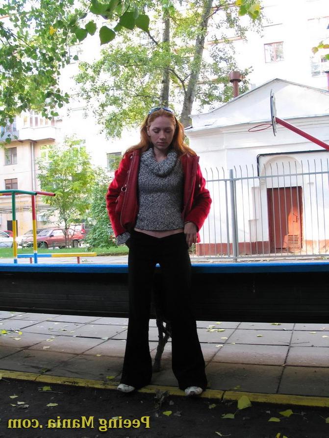 15P Naughty redhead gal pulls her jeans down and makes a pee on the bench
