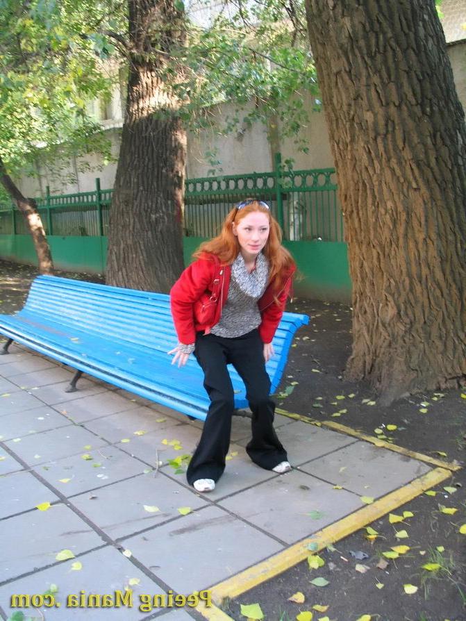 15P Naughty redhead gal pulls her jeans down and makes a pee on the bench