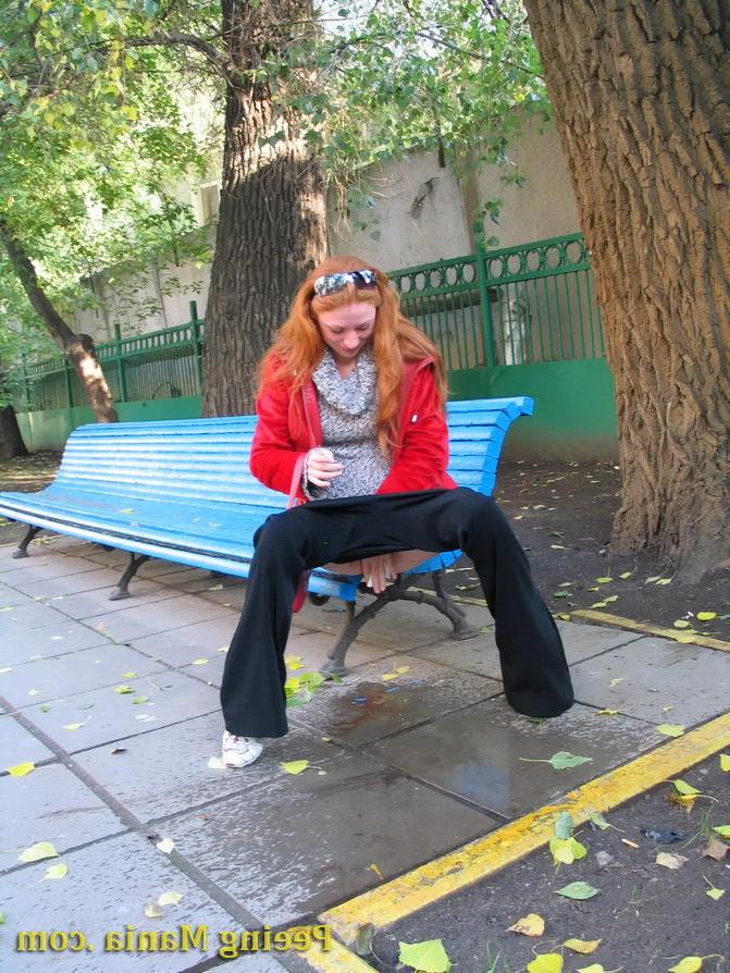 15P Naughty redhead gal pulls her jeans down and makes a pee on the bench
