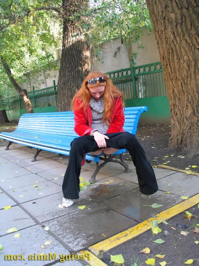 15P Naughty redhead gal pulls her jeans down and makes a pee on the bench