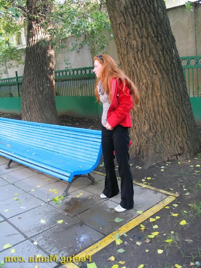 15P Naughty redhead gal pulls her jeans down and makes a pee on the bench