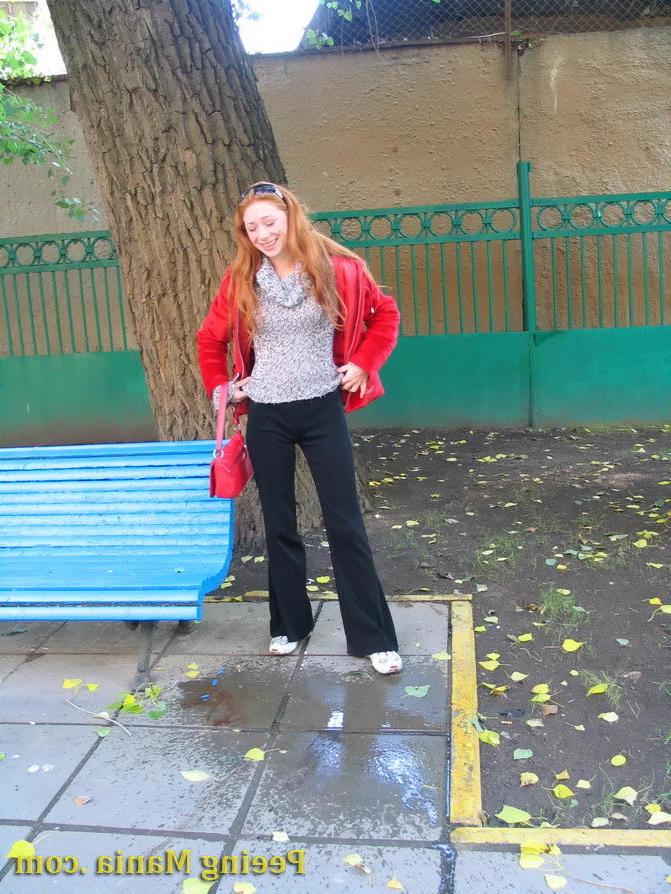 15P Naughty redhead gal pulls her jeans down and makes a pee on the bench