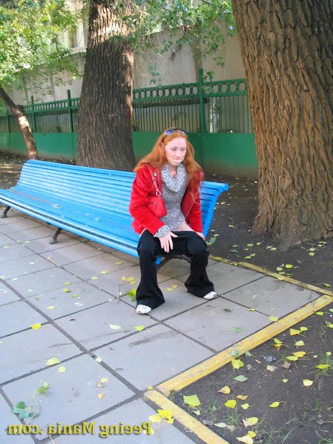 15P Naughty redhead gal pulls her jeans down and makes a pee on the bench