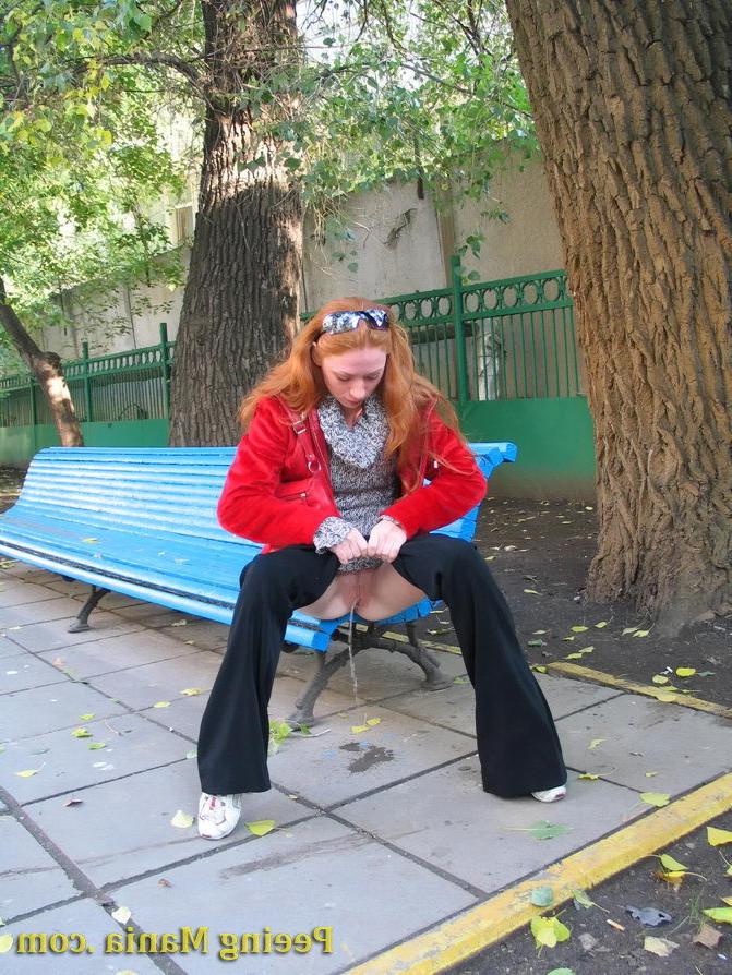 15P Naughty redhead gal pulls her jeans down and makes a pee on the bench