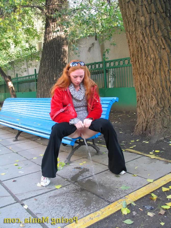 15P Naughty redhead gal pulls her jeans down and makes a pee on the bench