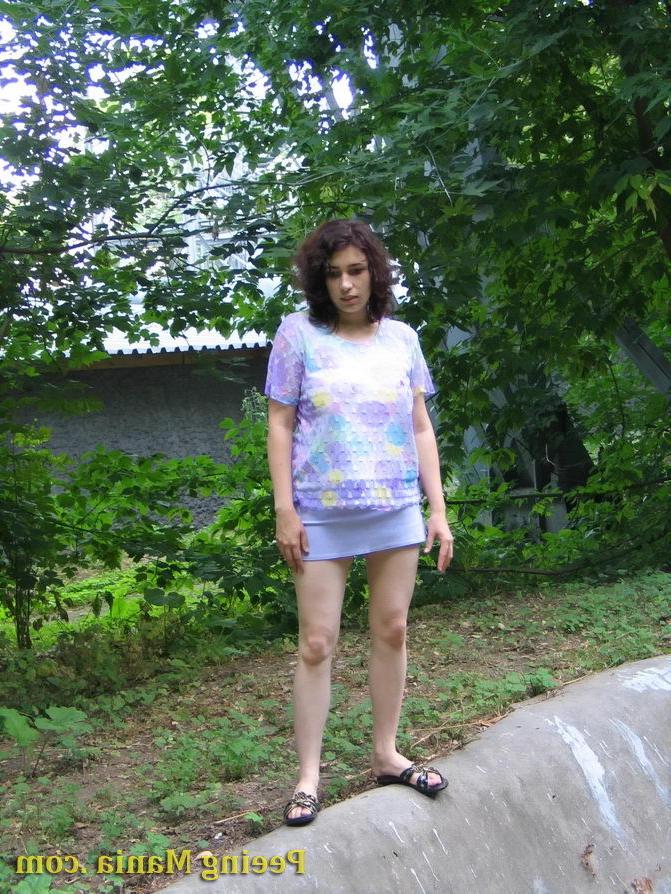 15P Pretty girl pulls up her short skirt and starts making a pee outdoors