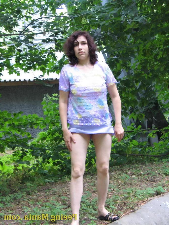 15P Pretty girl pulls up her short skirt and starts making a pee outdoors