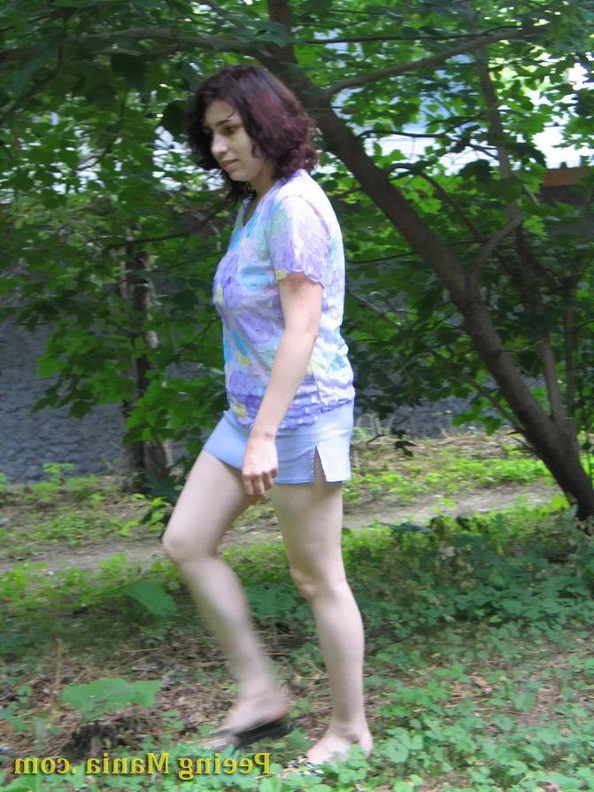 15P Pretty girl pulls up her short skirt and starts making a pee outdoors