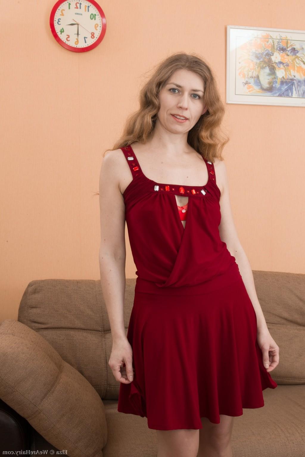 16P Elza strips naked on her brown couch looking sexy 
