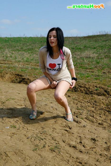 16P Brunette wets the sand under her feet with her pee