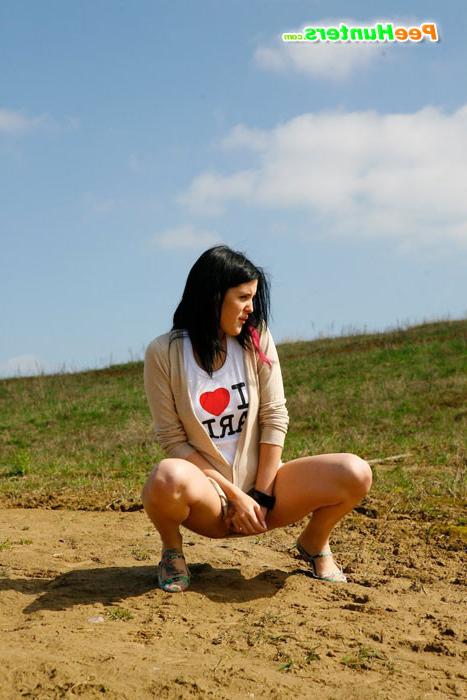16P Brunette wets the sand under her feet with her pee