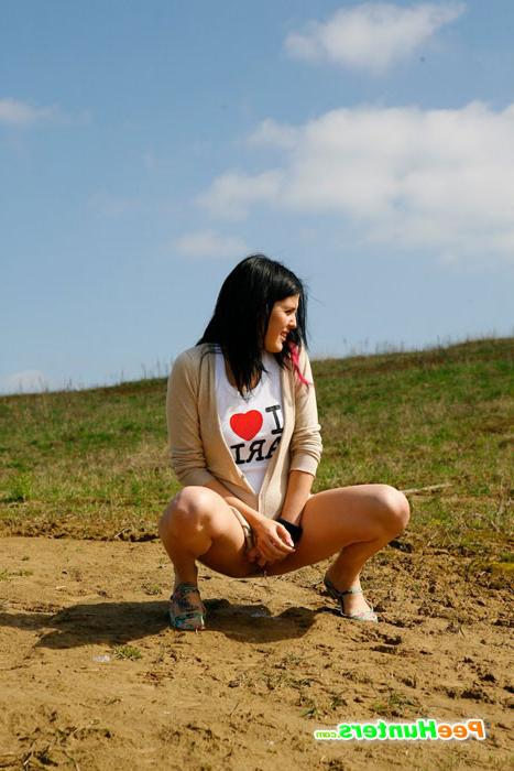 16P Brunette wets the sand under her feet with her pee