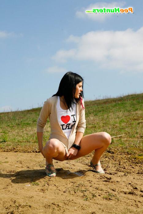 16P Brunette wets the sand under her feet with her pee