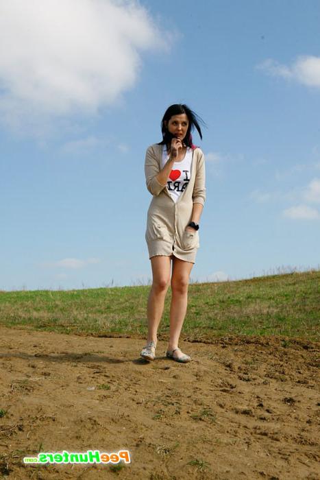 16P Brunette wets the sand under her feet with her pee