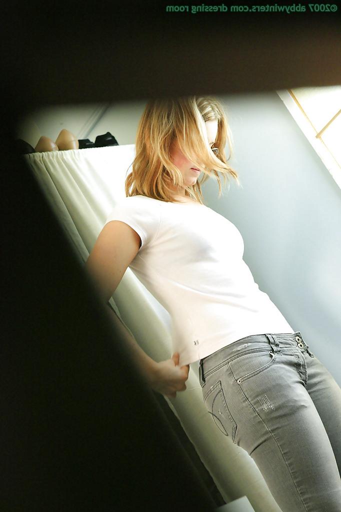 16P A secret camera captures a young blonde pulling on pink panties over ass