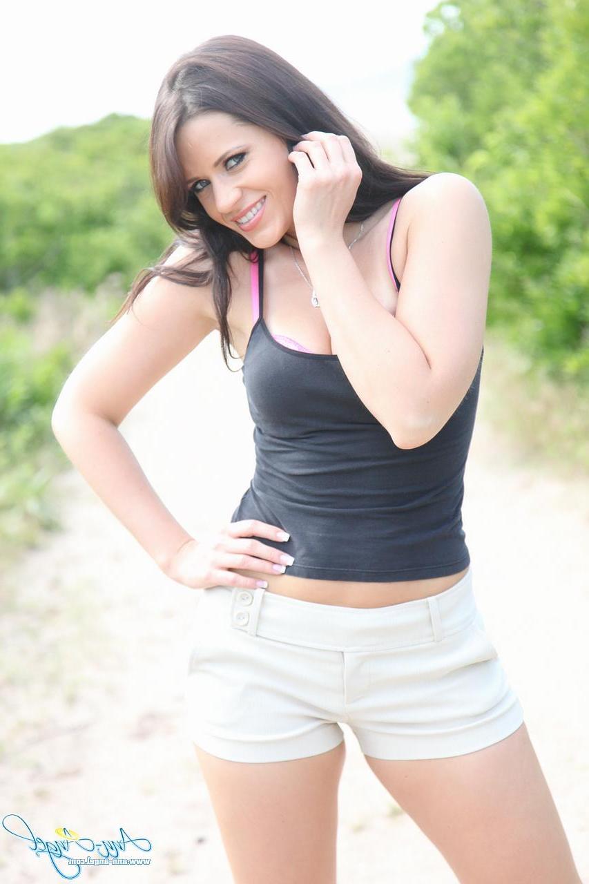 15P Pictures of Ann Angel giving a short shorts strip tease outdoors