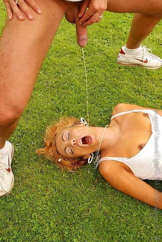 20P Two guys pissing over a redhead on an outdoor soccer field