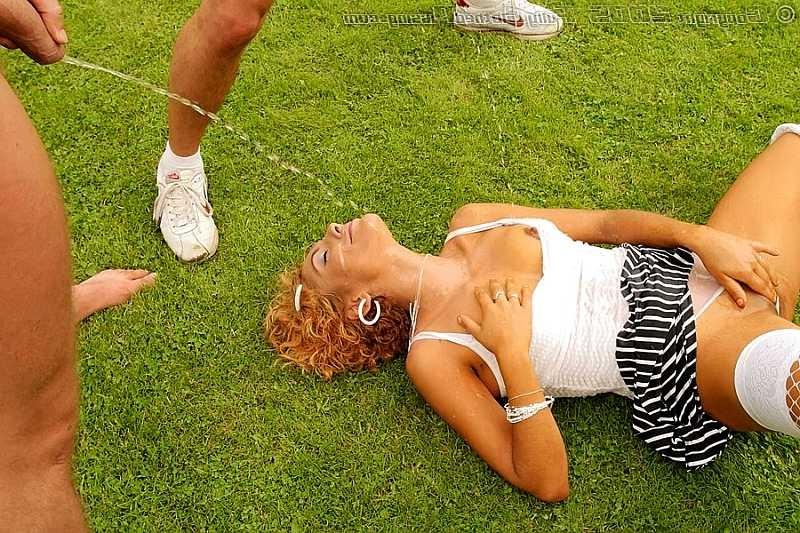 20P Two guys pissing over a redhead on an outdoor soccer field