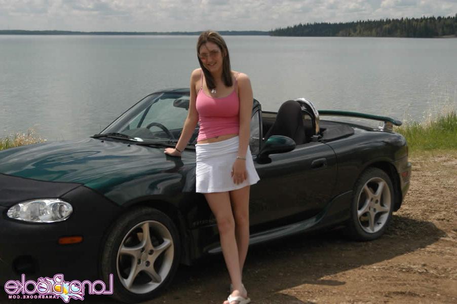 15P Brunette teen with big tits poses by a car