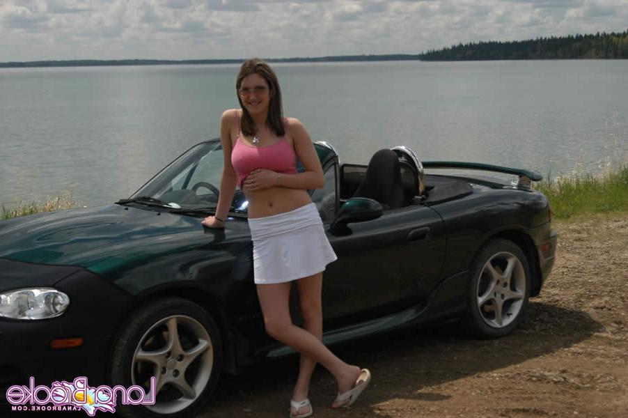 15P Brunette teen with big tits poses by a car