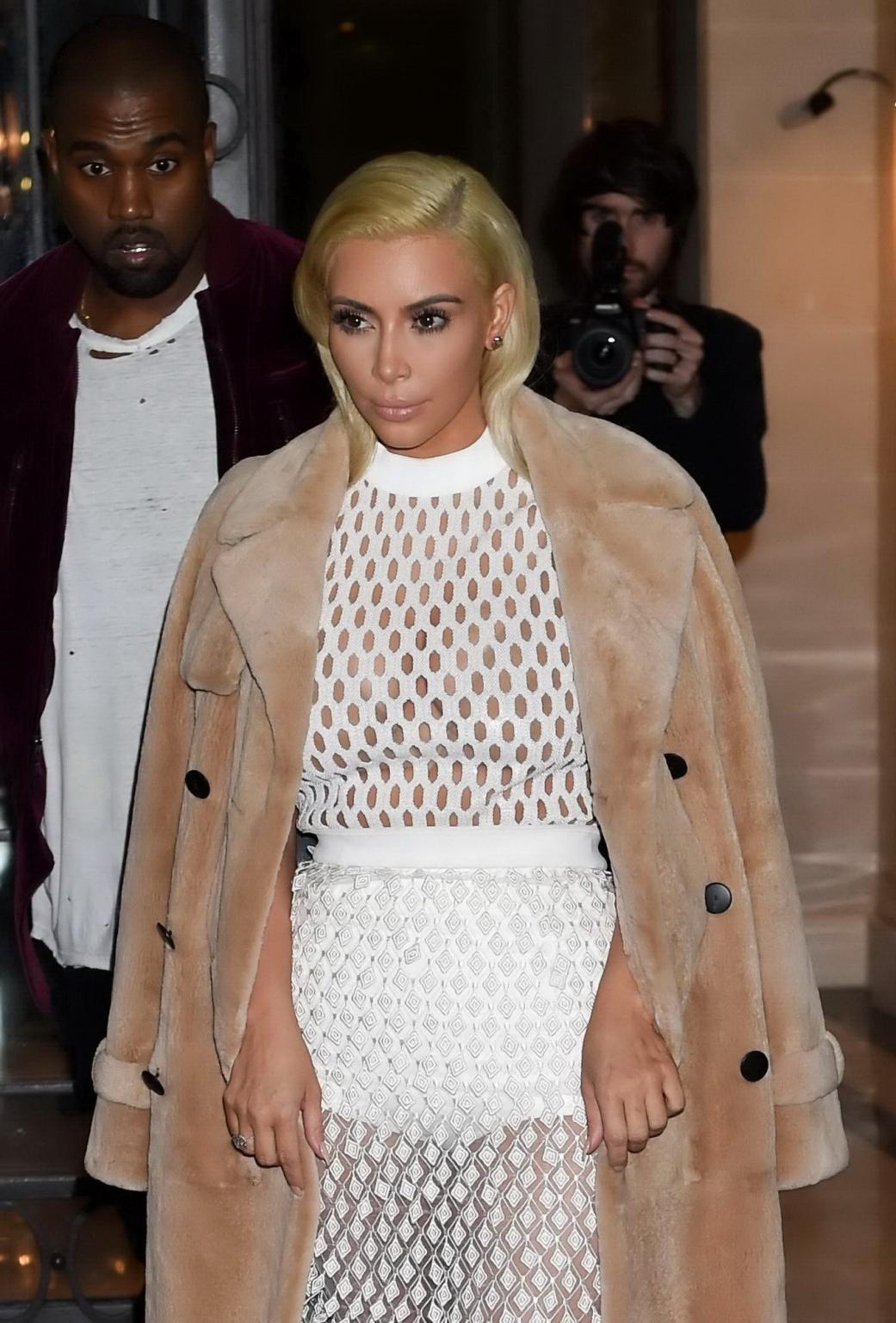 16P Kim Kardashian in a white mesh dress leaving her hotel in Paris