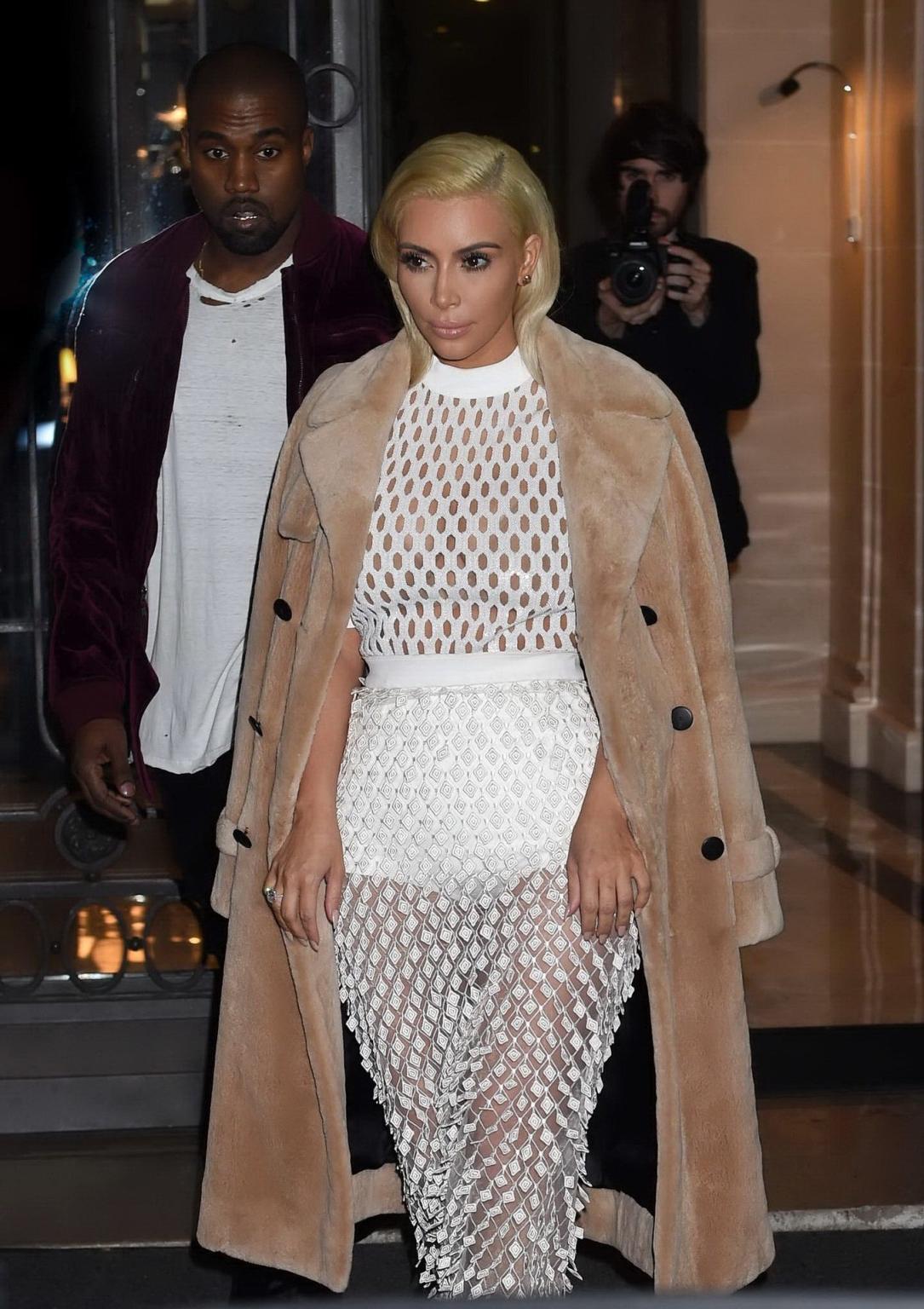 16P Kim Kardashian in a white mesh dress leaving her hotel in Paris