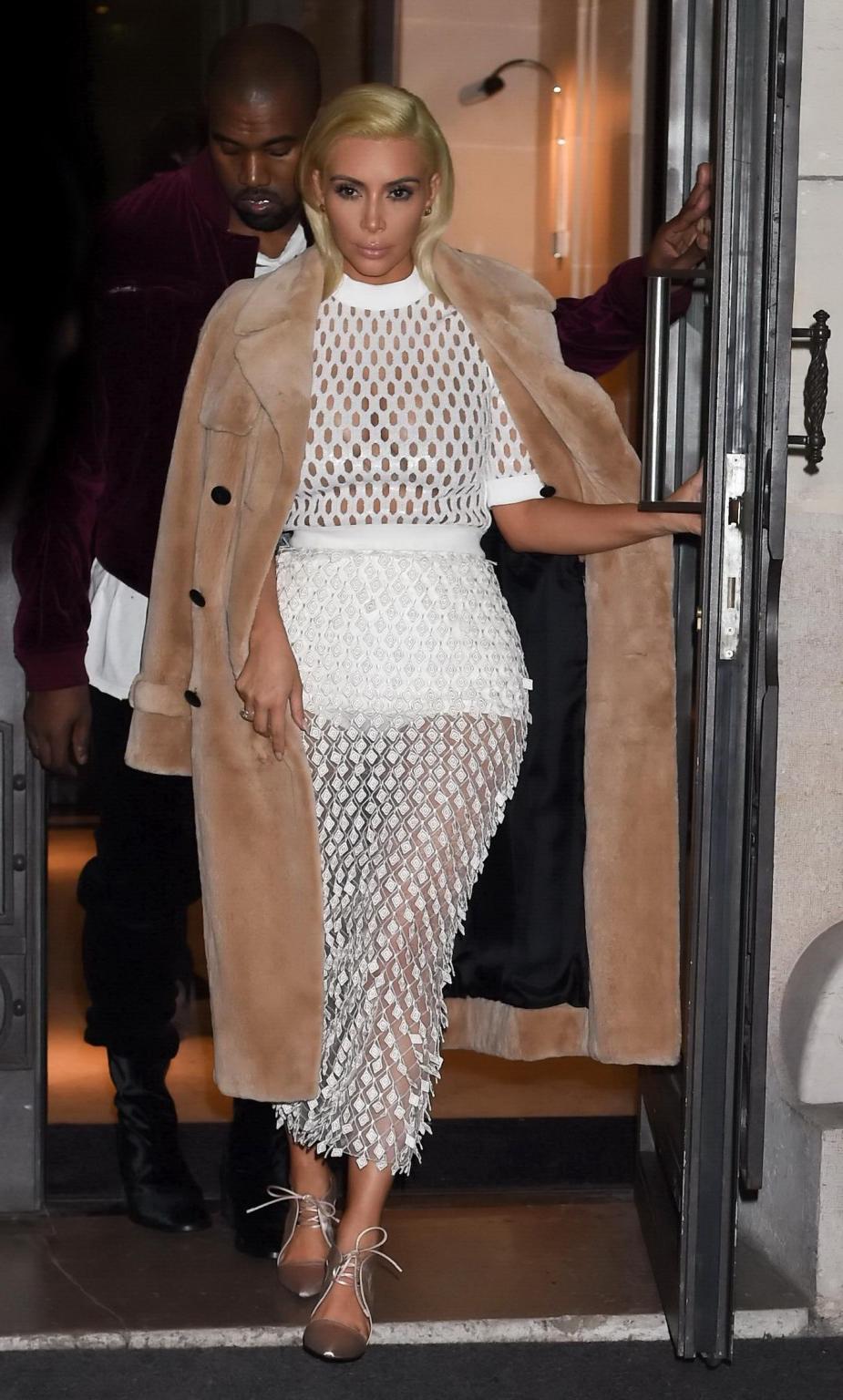 16P Kim Kardashian in a white mesh dress leaving her hotel in Paris