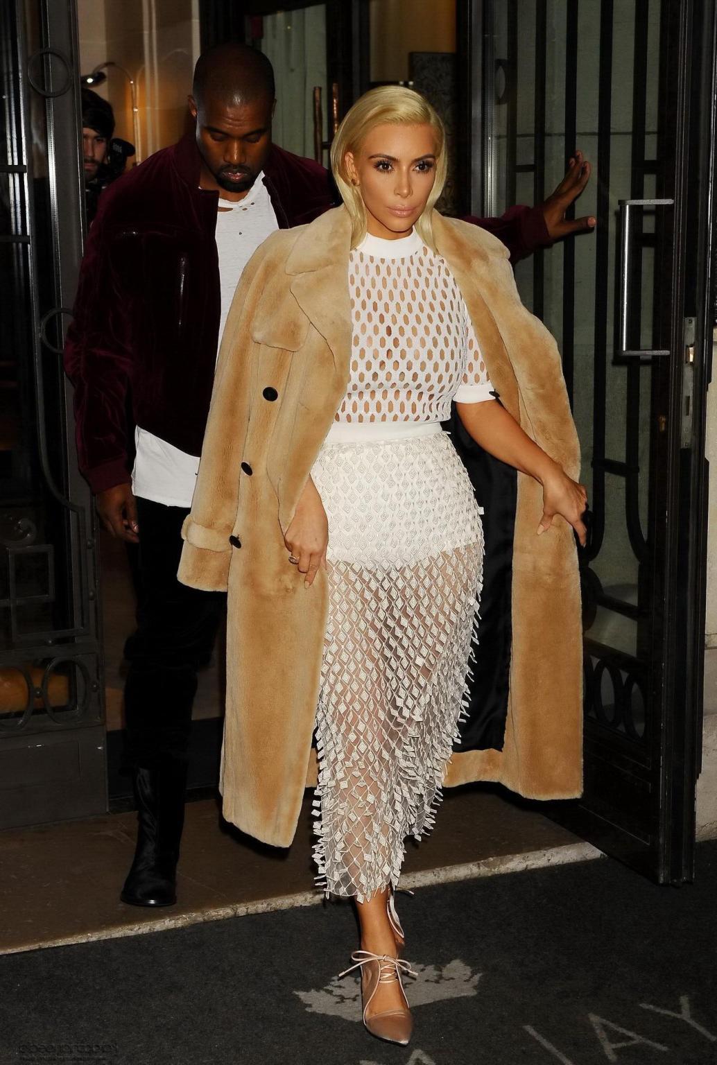 16P Kim Kardashian in a white mesh dress leaving her hotel in Paris
