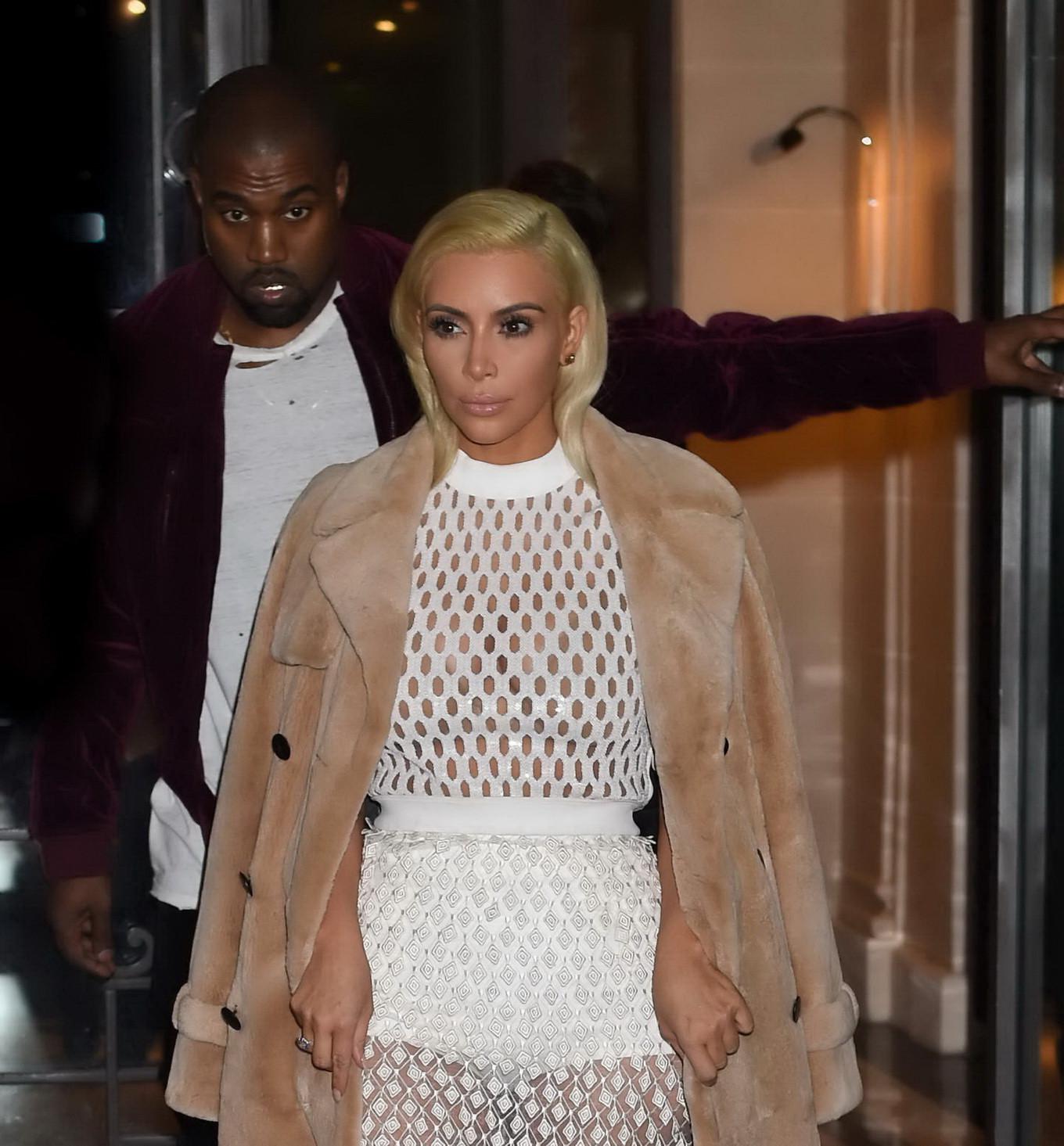 16P Kim Kardashian in a white mesh dress leaving her hotel in Paris