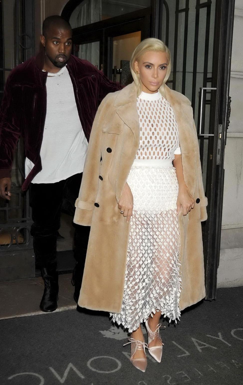 16P Kim Kardashian in a white mesh dress leaving her hotel in Paris
