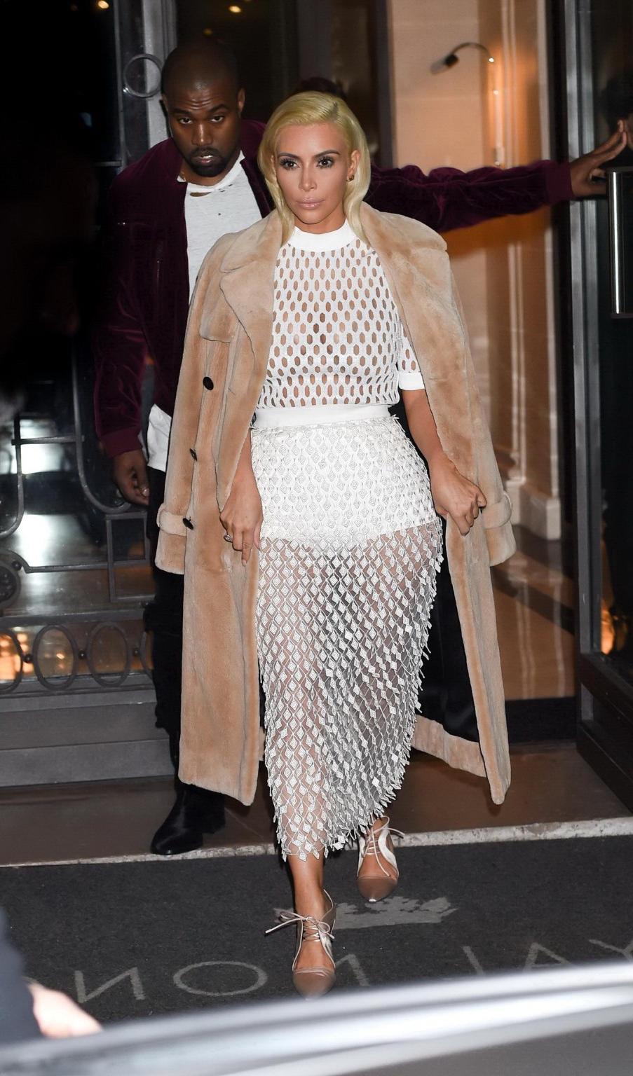 16P Kim Kardashian in a white mesh dress leaving her hotel in Paris