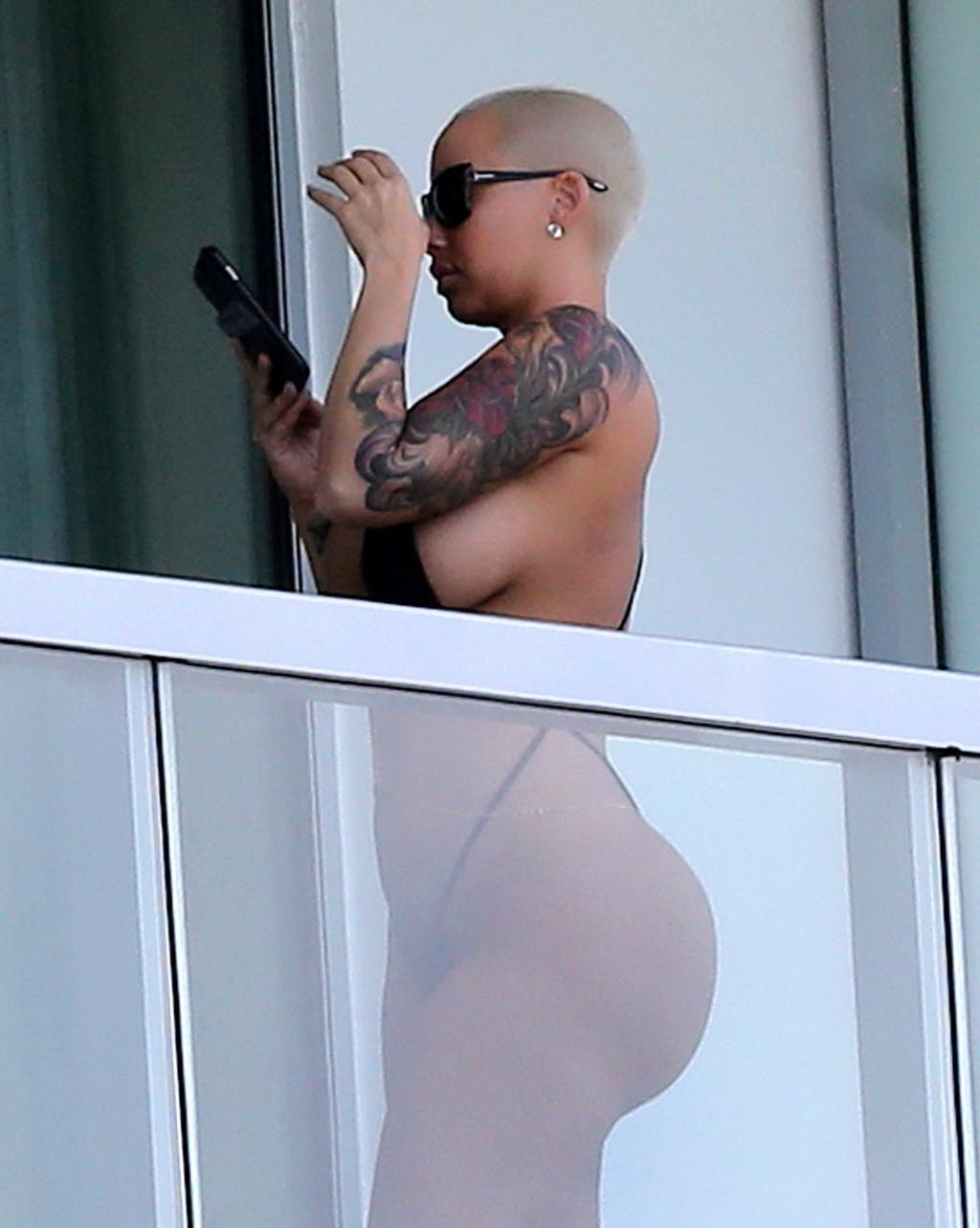 16P Amber Rose shows off her round ass wearing a tiny black monokini on a hotel balc