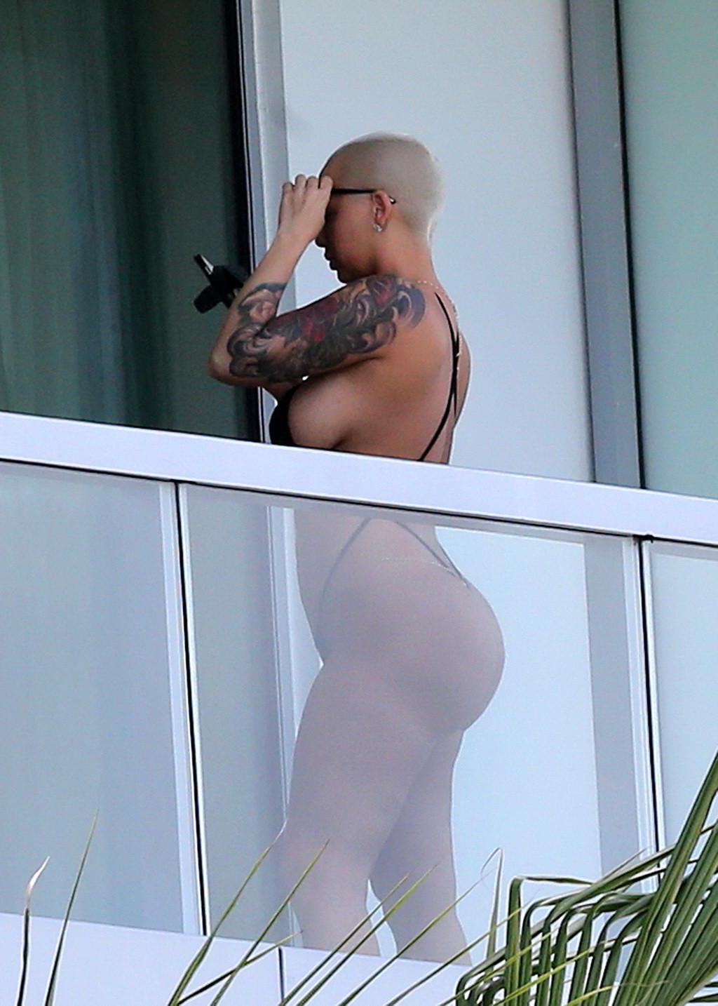 16P Amber Rose shows off her round ass wearing a tiny black monokini on a hotel balc