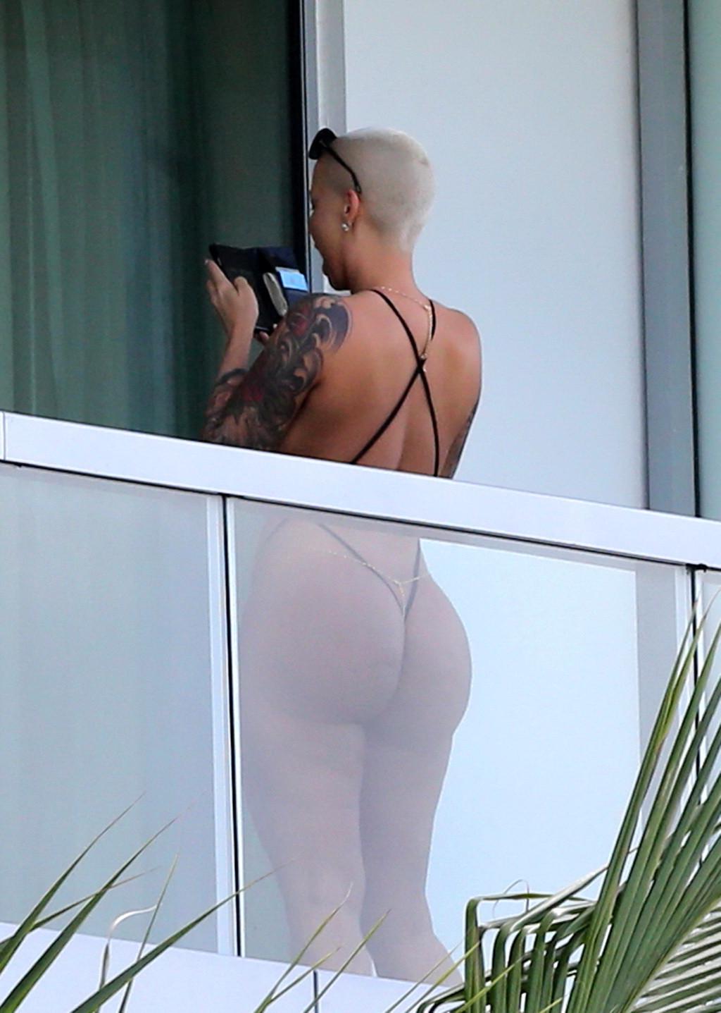 16P Amber Rose shows off her round ass wearing a tiny black monokini on a hotel balc