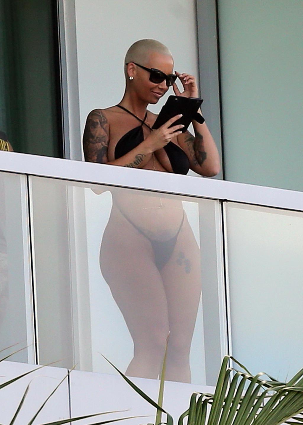 16P Amber Rose shows off her round ass wearing a tiny black monokini on a hotel balc