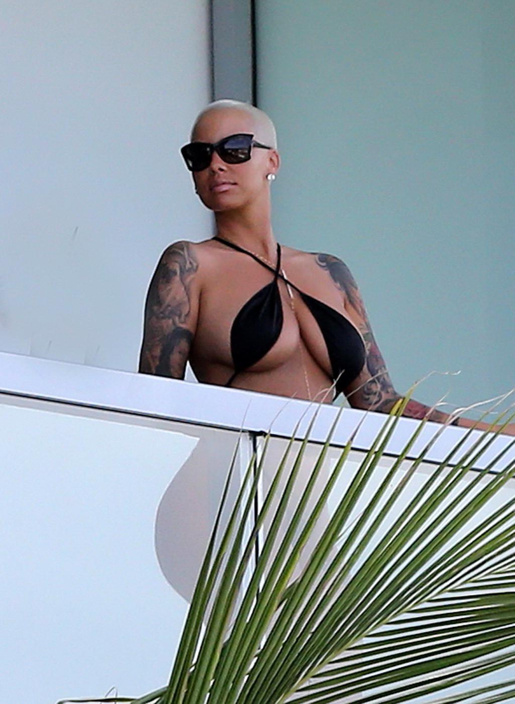 16P Amber Rose shows off her round ass wearing a tiny black monokini on a hotel balc